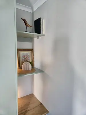 a room with shelves with a bird on the wall at Sand & Sea Studio Hermanus in Hermanus