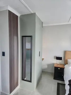 a hotel room with a mirror and a bed at Sand & Sea Studio Hermanus in Hermanus
