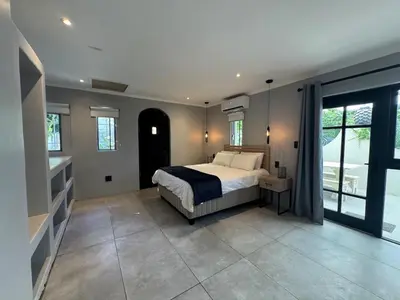 a bedroom with a bed and a large window at One-Bedroom apartment in Somerset West in Helderberg