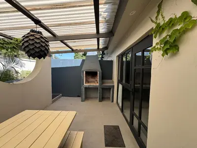 an outdoor patio with a table and a grill at One-Bedroom apartment in Somerset West in Helderberg