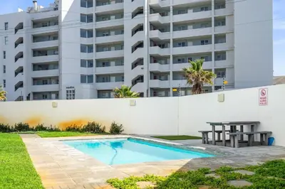 a swimming pool in front of a building at Beach Break 17 in Cape Town