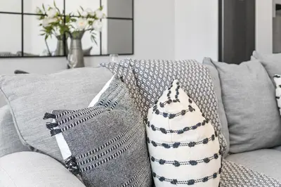 a gray couch with pillows on it with at Beach Break 17 in Cape Town