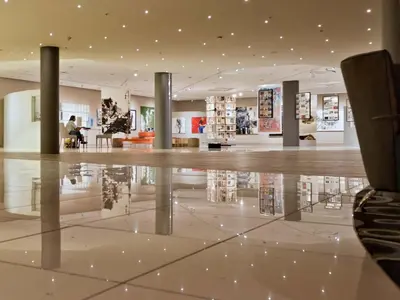a lobby with a reflection in the floor of a building at Krystal Beach Hotel in Gordonʼs Bay