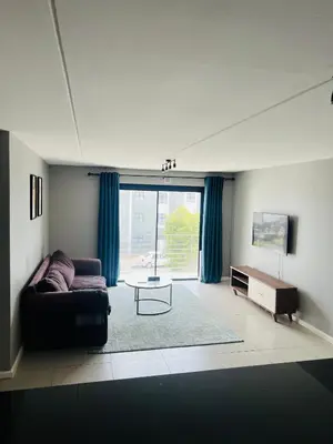 a living room with a couch and a table at Minimalist 2 bed 1 full bathroom in Cape Town