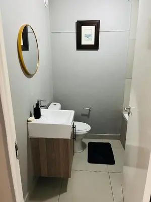 a bathroom with a sink and a mirror and a toilet at Minimalist 2 bed 1 full bathroom in Cape Town