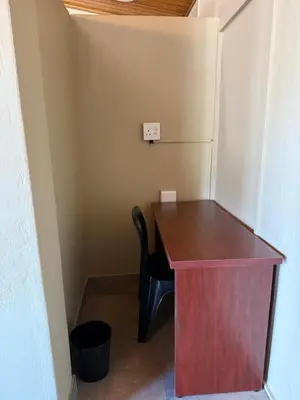a desk in a room with a chair and a refrigerator at Kabana Guest House Morgenzicht in Windsor Park