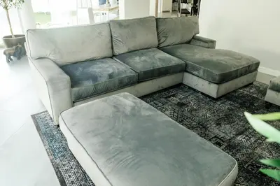 a gray couch in a living room with a rug at Beach House in Sunset Beach in Cape Town