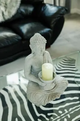 a statue of a woman holding a candle on a table at Beach House in Sunset Beach in Cape Town
