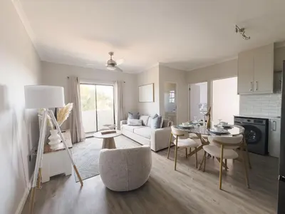 a living room with a table and a couch at Manchester Heights Deluxe Apartments in Cape Town