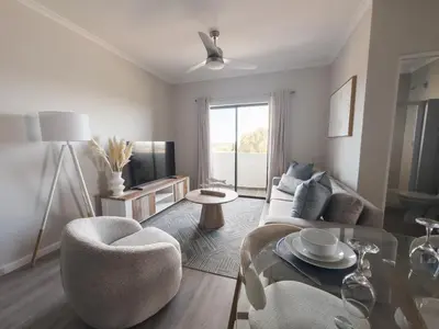 a living room with a couch and a table at Manchester Heights Deluxe Apartments in Cape Town