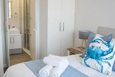 a bedroom with a bed with towels on it at Manchester Heights Deluxe Apartments in Cape Town