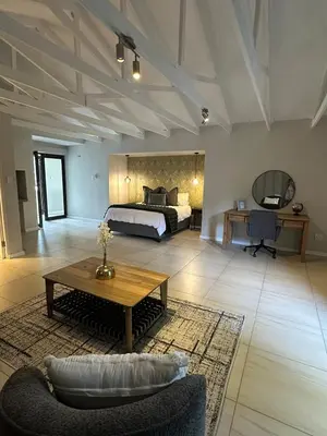 a large bedroom with a bed and a coffee table at Luxe Stay Somerset West 4 in Somerset West