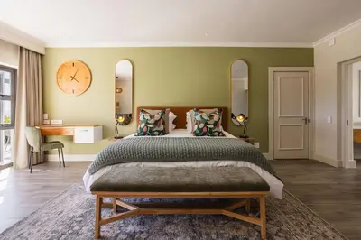 a bedroom with a large bed and a clock on the wall at Winelands Luxury Accommodation in Stellenbosch