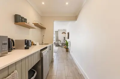 a kitchen with white walls and a long counter at Winelands Luxury Unit in Stellenbosch