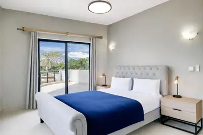 a bedroom with a large bed and a large window at Belina - Knightsbridge Prestige Suite in Cape Town