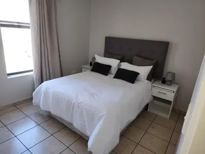 a bedroom with a large white bed with two pillows at Stepney Apartment in Cape Town