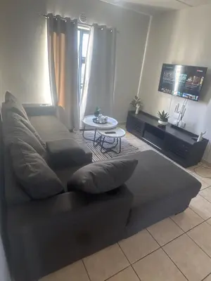 a living room with a couch and a table at Stepney Apartment in Cape Town