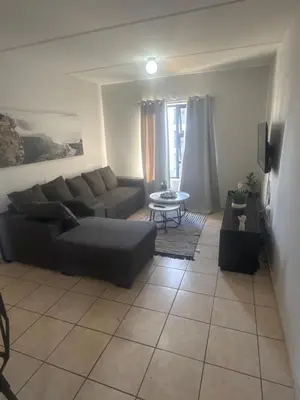 a living room with a couch and a table at Stepney Apartment in Cape Town