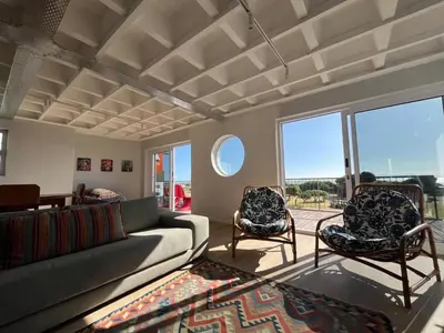a living room with a couch and two chairs at Salted in Cape Town