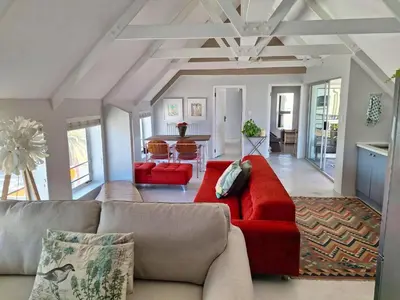 a living room with a red couch and a table at Salted in Cape Town