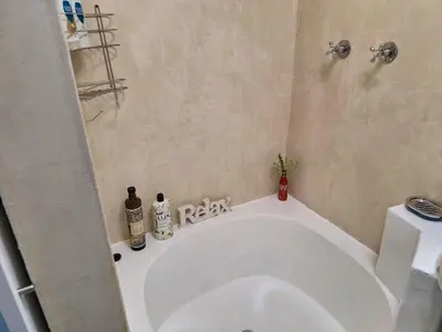 a bathroom with a large white tub in a room at Salted in Cape Town