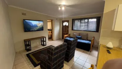 a living room with a couch and a tv at Casa Kari in Brackenfell