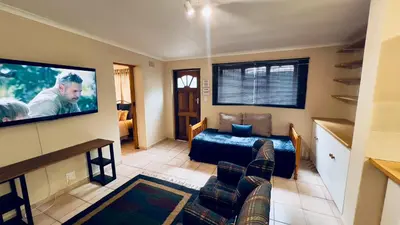a living room with a couch and a flat screen tv at Casa Kari in Brackenfell