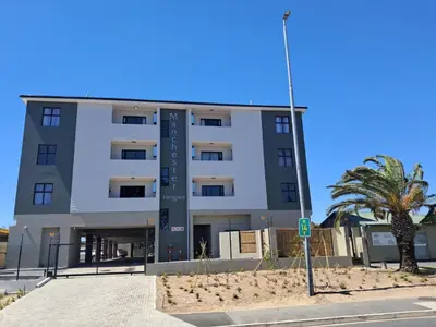 a building with a palm tree in front of it at Fresh Air in Cape Town