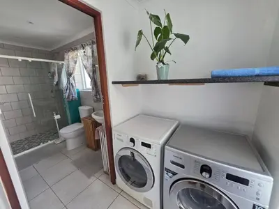 a laundry room with a washer and dryer in it at Alvera in Strand