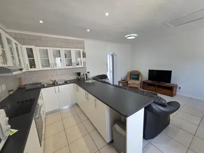 a kitchen with white cabinets and a black counter top at Alvera in Strand