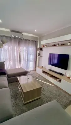 a living room with a couch and a flat screen tv at Your Perfect Little Cozy Getaway in Cape Town