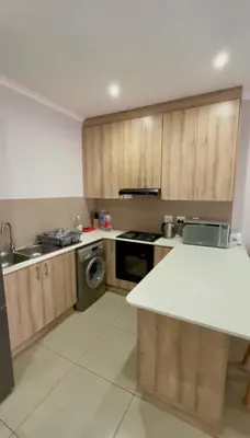 a kitchen with wooden cabinets and a sink and a stove at Your Perfect Little Cozy Getaway in Cape Town