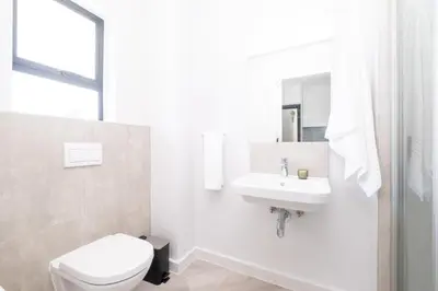 a white bathroom with a toilet and a sink at 113 Paarl 2 Bedroom Lux Aprt With Parking & Aircon in Paarl