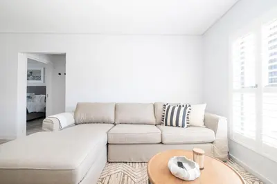 a white living room with a couch and a table at 113 Paarl 2 Bedroom Lux Aprt With Parking & Aircon in Paarl