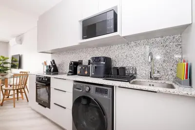 a kitchen with a washing machine and a sink at 113 Paarl 2 Bedroom Lux Aprt With Parking & Aircon in Paarl