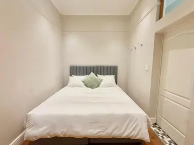 a bedroom with a white bed with a green pillow at 3 Bedroom Vintage Home in Cape Town