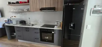 a kitchen with a black refrigerator and a sink at Ebbies place in Cape Town