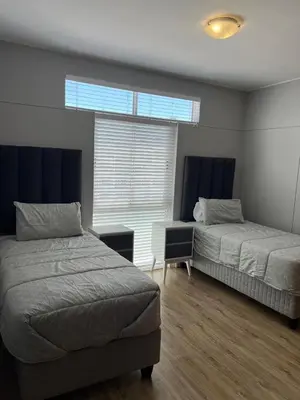 a bedroom with two beds and a window at Strandsig 308, 96 beach road in Strand
