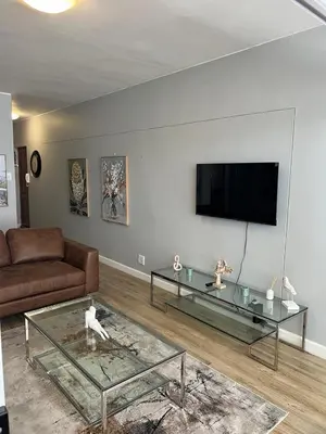 a living room with a couch and a flat screen tv at Strandsig 308, 96 beach road in Strand