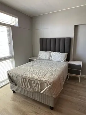 a bedroom with a large bed with a gray headboard at Strandsig 308, 96 beach road in Strand
