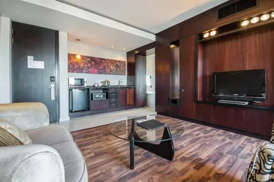 a living room with a couch and a tv at Colosseum Hotel in Cape Town
