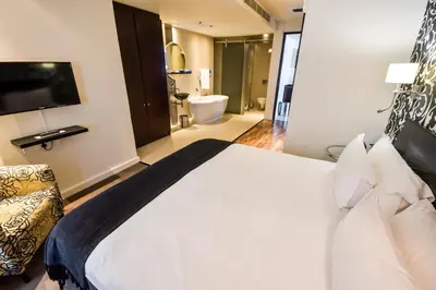 a bedroom with a large bed and a bathroom at Colosseum Hotel in Cape Town