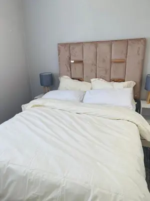 a large white bed with white sheets and pillows at Cape Coral in Cape Town