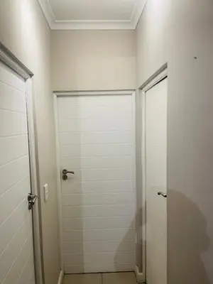 a white closet with two doors in a room at Cape Coral in Cape Town
