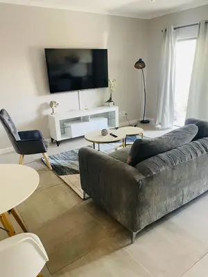a living room with a couch and a flat screen tv at Cape Coral in Cape Town