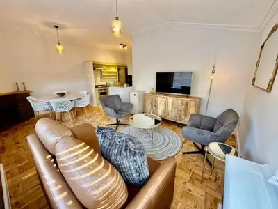 a living room with a leather couch and chairs and a table at 26 at Blumenhof in Stellenbosch