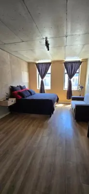 a large room with two beds and two windows at Ebbies place in Cape Town