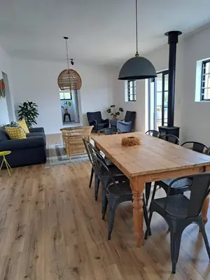 a living room with a wooden table and chairs at Beaumont Family Wines in Botrivier