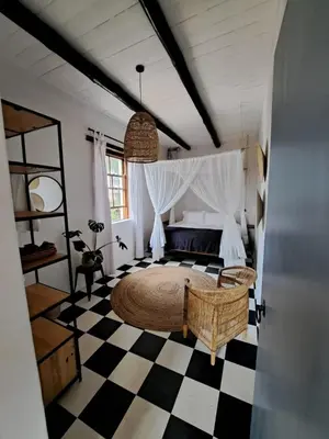 a bedroom with a large bed and a checkered floor at Beaumont Family Wines in Botrivier