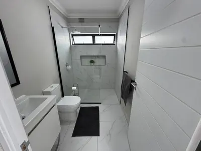a white bathroom with a toilet and a sink at Lansdowne Lodge in Welton